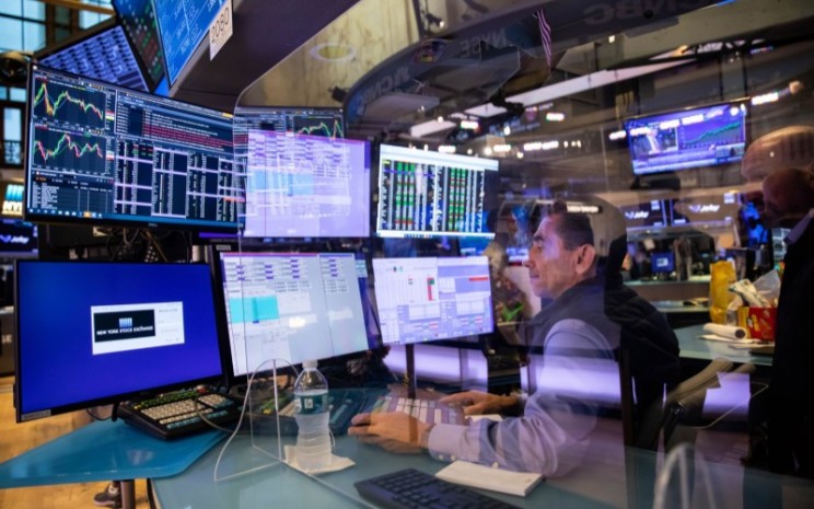 Seorang pelaku pasar tengah memantau pergerakan harga saham di bursa New York Stock Exchange (NYSE), New York, Amerika Serikat. - Bloomberg