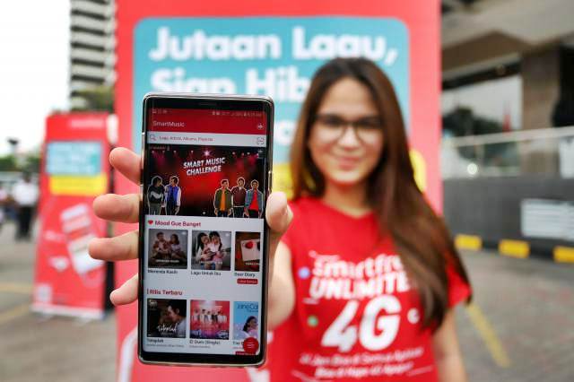 Model memperlihatkan aplikasi khusus streaming musik dari Smartfren yaitu SmartMusic saat peluncurannya di Jakarta, Minggu (10/2/2019). - Bisnis/Abdullah Azzam