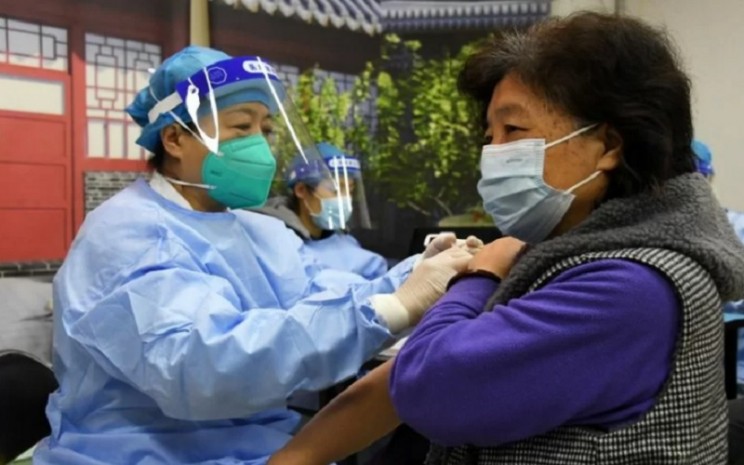 Seorang tenaga kesehatan memberikan suntikan penguat (booster) vaksin COVID-19 kepada warga setempat di sebuah lokasi vaksinasi sementara di Beijing, China pada 29 November 2021. - Antra/Xinhua