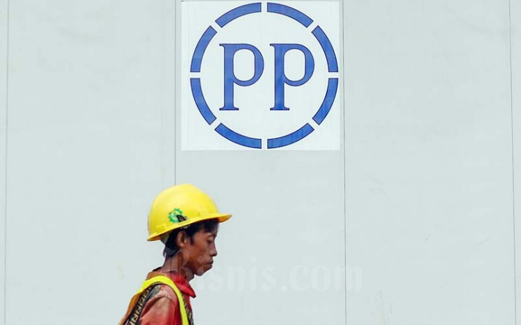 Pekerja melintas di dekat logo PT PP Properti Tbk. (PPRO) di Jakarta, Kamis (20/1/2022). Bisnis - Fanny Kusumawardhani