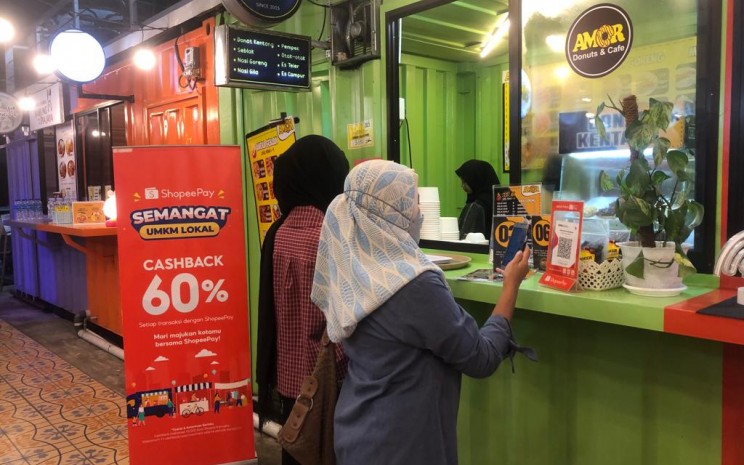 Keterangan foto: Tampak seorang pengunjung sedang melakukan transaksi menggunakan ShopeePay sembari menikmati promo Cashback 60% di pusat UMKM Waka/Waka Balikpapan