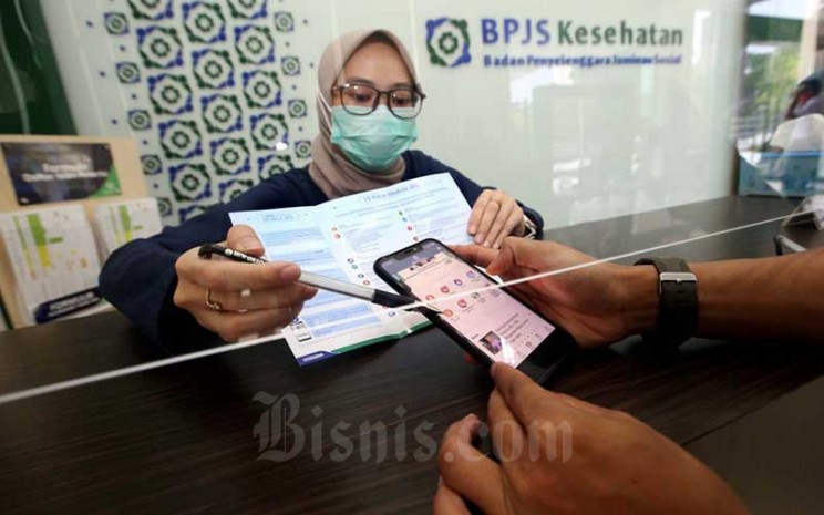 Petugas menjelaskan kepada peserta tentang fitur-fitur yang ada di aplikasi Mobile JKN di Kantor BPJS Kesehatan Cabang Bandung, Jawa Barat, Kamis (13/8/2020). Bisnis - Rachman