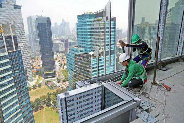 Pekerja PT Nusa Konstruksi Enjiniring Tbk (NKE) menyelesaikan pembangunan gedung World Capital Tower (WCT) setinggi 54 lantai milik Pollux Properties Group, di Mega Kuningan, Jakarta, Rabu (13/9). - ANTARA 