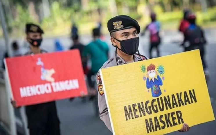 Personel gabungan TNI dan Polri membagikan masker saat kampanye Protokol Kesehatan Covid-19 di kawasan Pasar Tanah Abang, Jakarta, Minggu (31/1/2021). - Antara