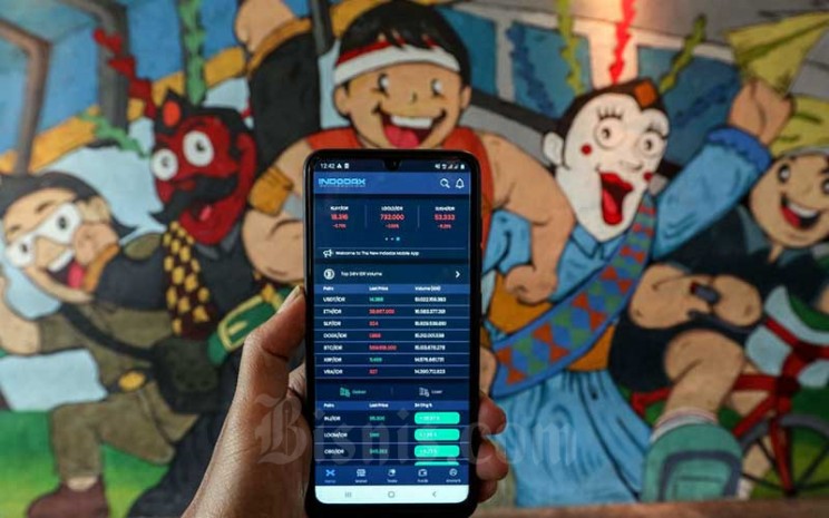 Investor memantau pergerakan harga kripto melalui ponselnya di Jakarta, Minggu (20/2/2022). Bisnis - Eusebio Chrysnamurti