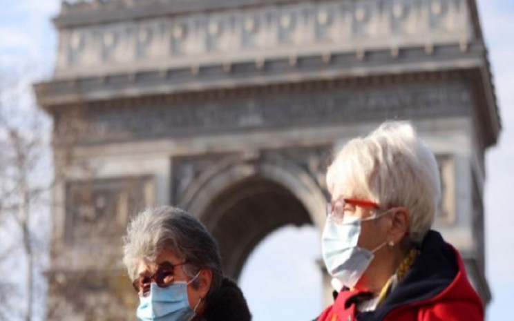 Ilustrasi orang-orang yang memakai masker berjalan di dekat Arc de Triomphe di Paris, Prancis, pada 23 Desember 2021. - Antara