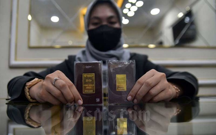 Karyawan menunjukan emas batangan di Galeri 24 Pegadaian, Jakarta, Senin (14/2/2022). Bisnis - Fanny Kusumawardhani