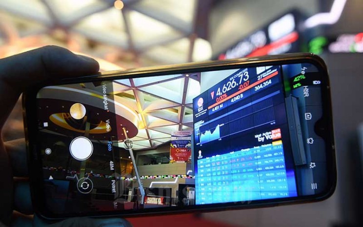 Pengunjung memotret layar monitor perdagangan Indeks Saham Gabungan (IHSG) di Bursa Efek Indonesia, Jakarta, Rabu (27/7/2020). Bisnis - Abdurachman