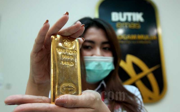Karyawati menunjukkan replika logam mulia di Butik Emas Antam, Jakarta, Kamis (6/8/2020). Bisnis - Arief Hermawan P