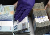 Pegawai money changer merapikan uang nominal Rp50.000 dan Rp100.000 di Jakarta, Indonesia, Selasa (18/8/2020)./Bloomberg-Dimas Ardian