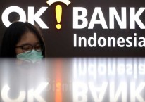 Karyawan berada di depan logo PT Bank Oke Indonesia Tbk. (DNAR) di Jakarta, Jumat (8/5/2020). Bisnis/Abdullah Azzam
